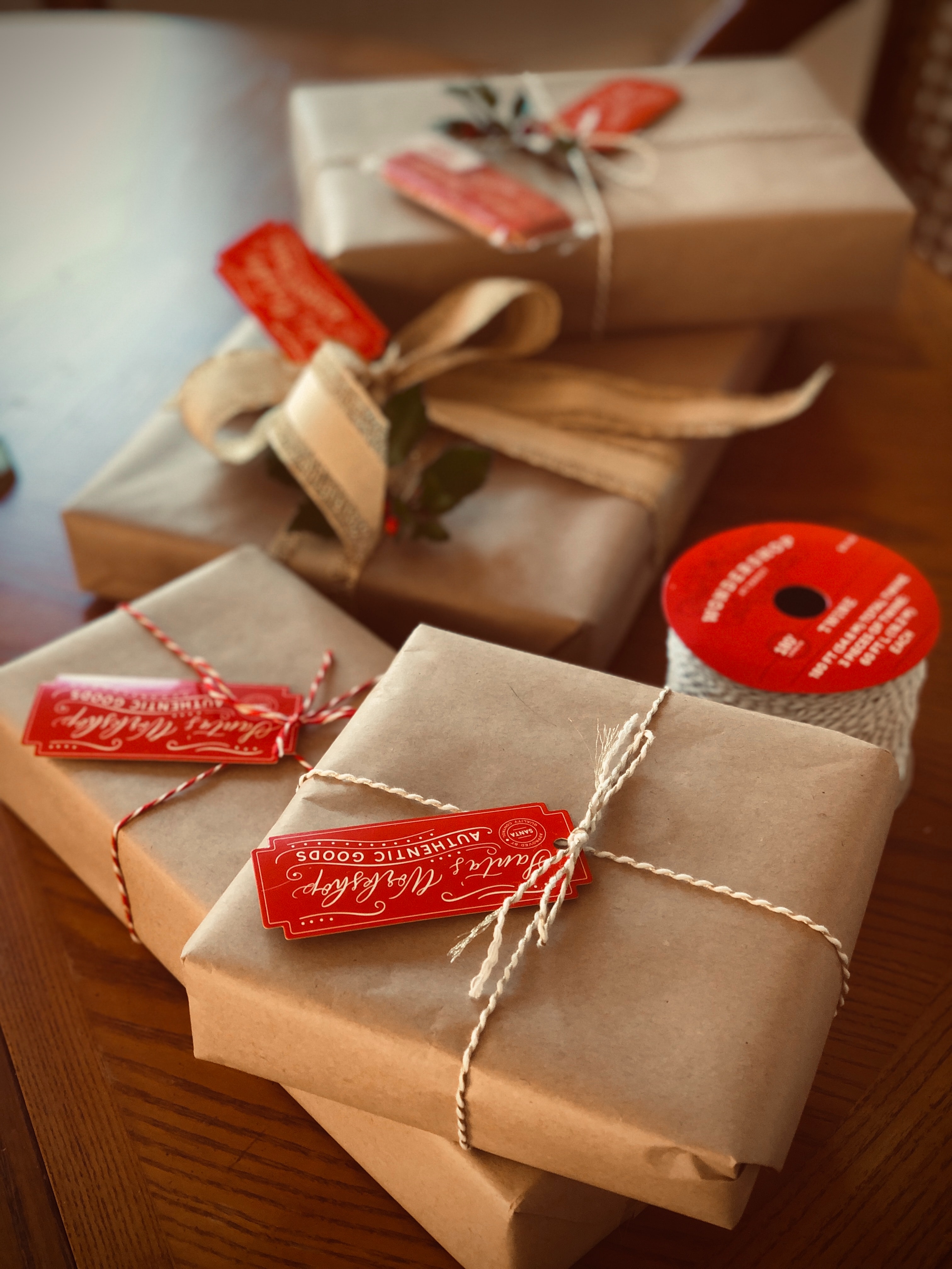 Holiday gifts in brown wrapping paper with festive red tags